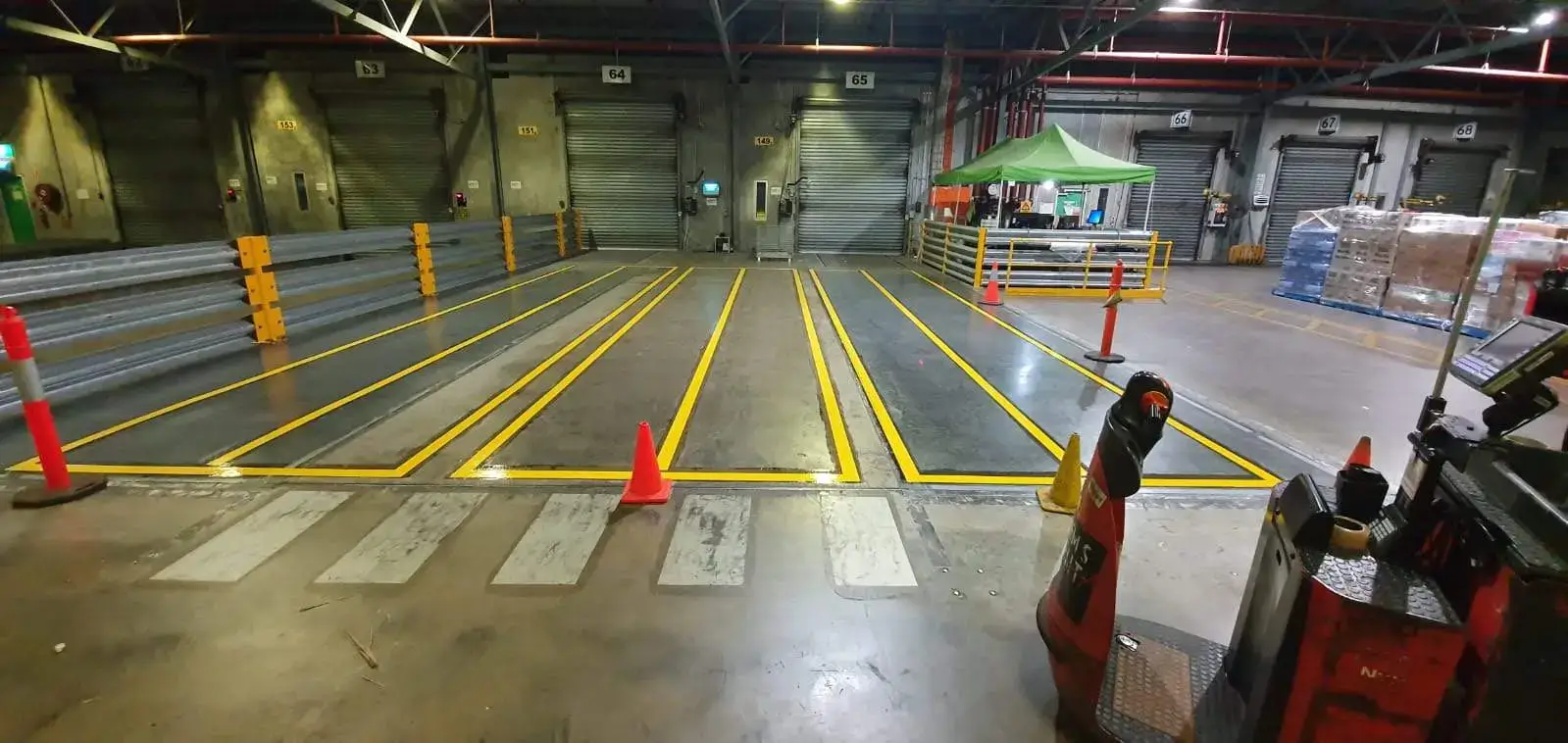Yellow forklift lanes and loading bay layout inside an industrial warehouse