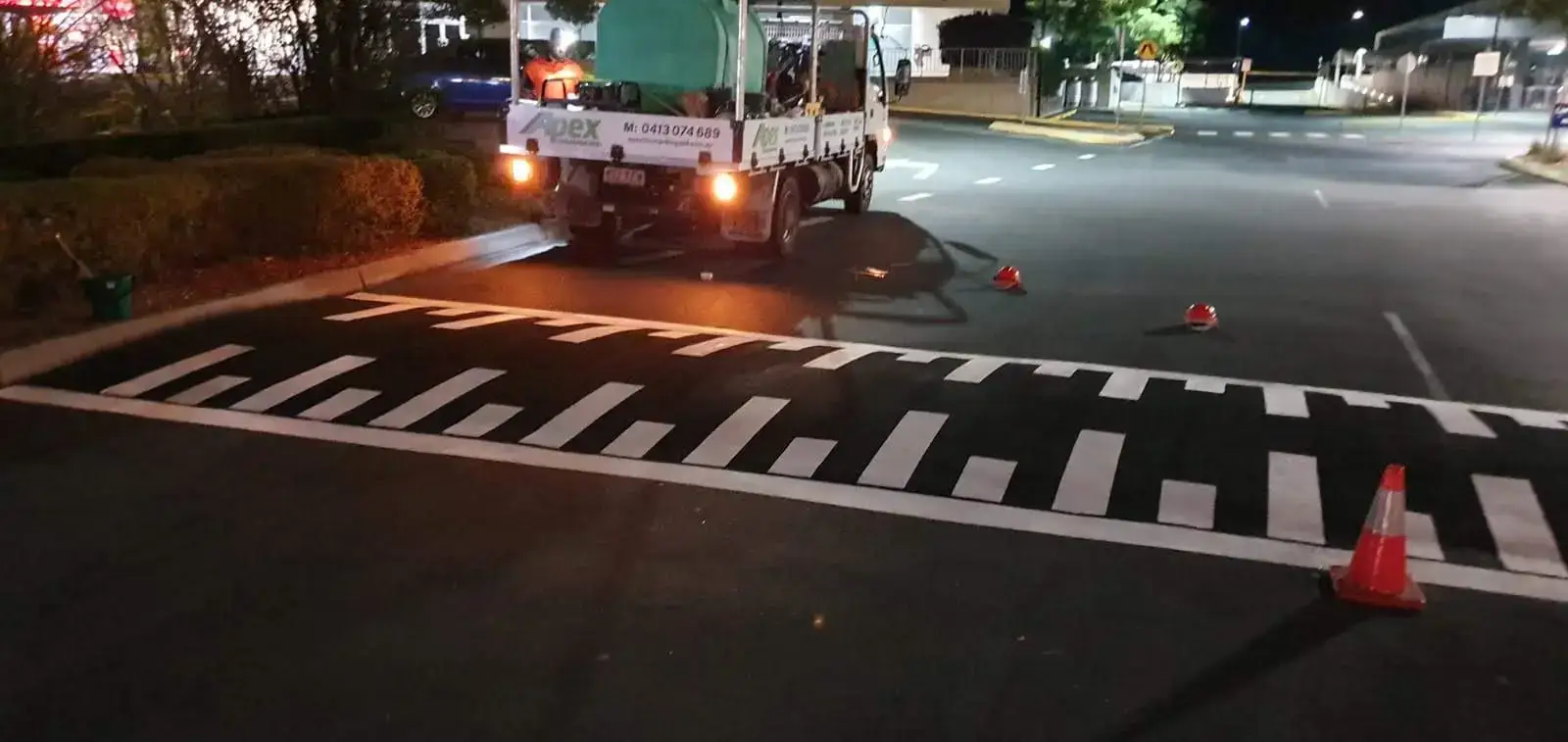 Piano key speed bump marked at night with the Apex truck and safety cones in the background