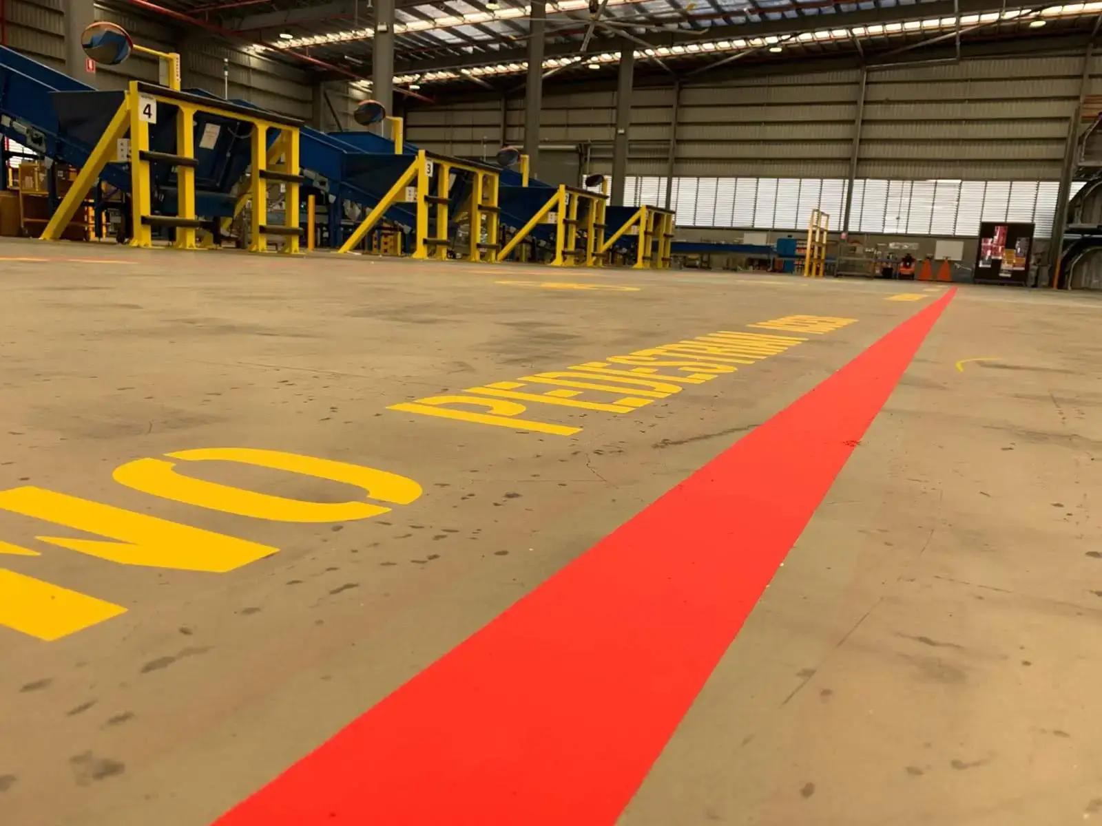Large warehouse floor with yellow NO text and a red directional arrow