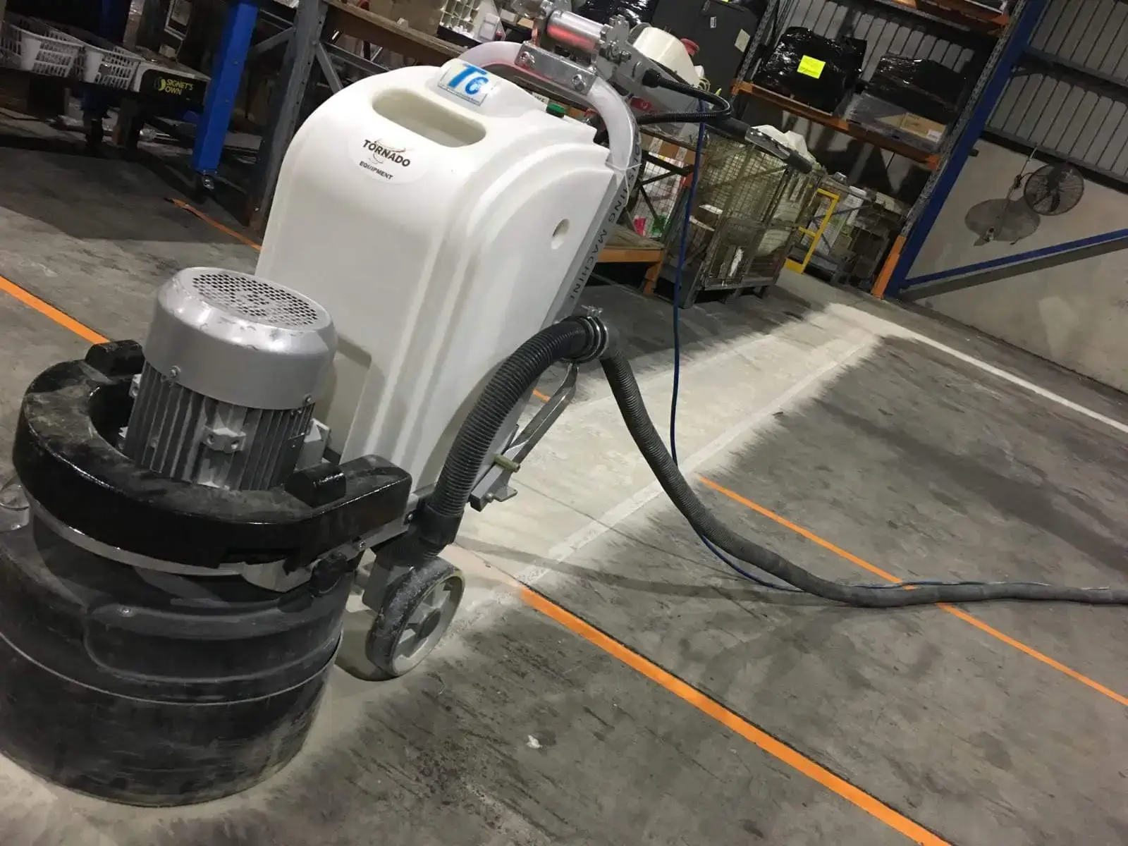 Floor grinding machine removing old line marking in a warehouse