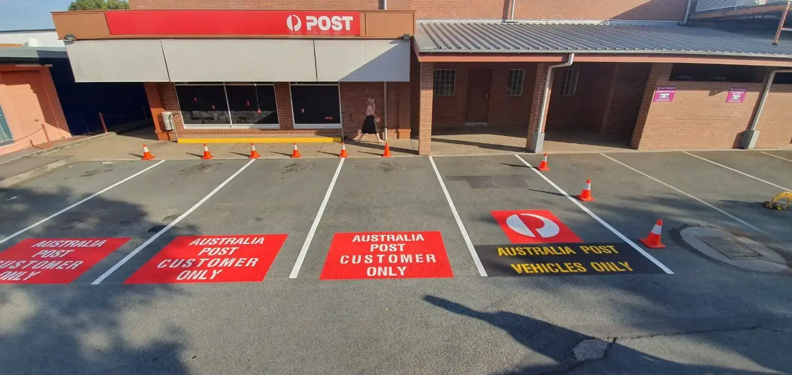 Australia Post car park with red customer parking signage and fresh white bay lines