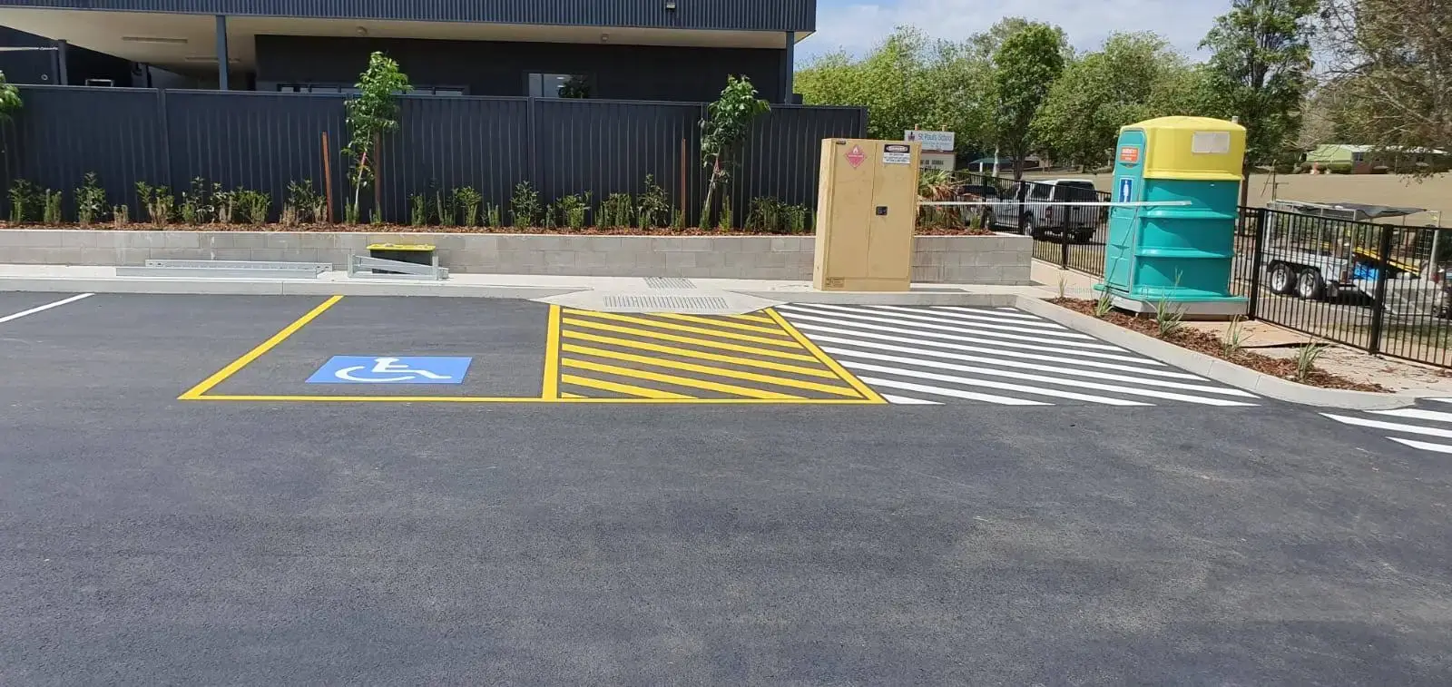 AS 2890.6 compliant disabled parking bay with blue wheelchair symbol and pedestrian crossing