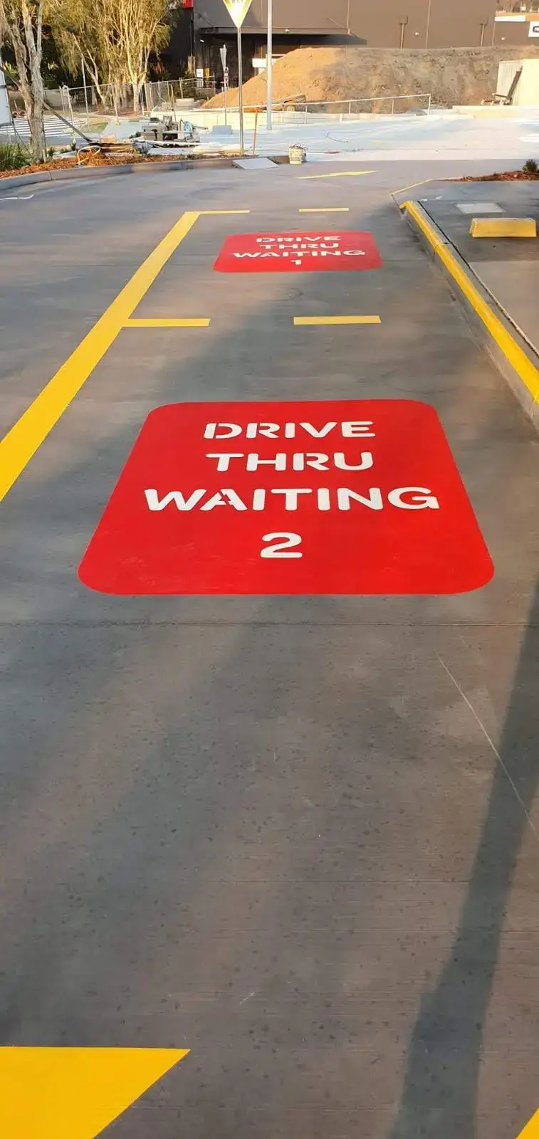 Red DRIVE THRU WAITING numbered bays with yellow lane markings