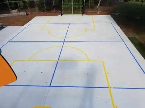 Multi-sport court freshly marked in yellow and blue by Apex Line Marking