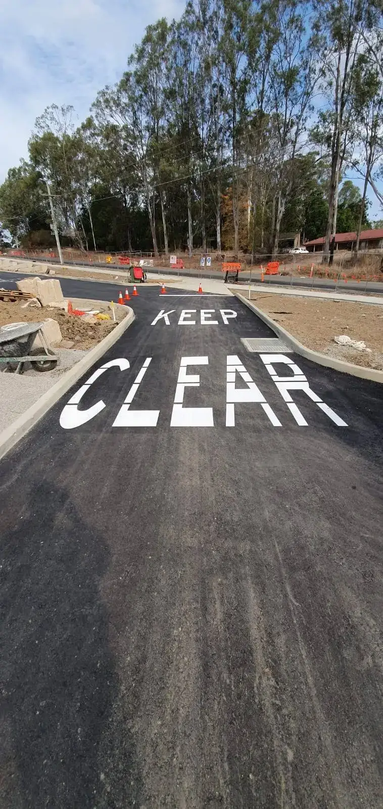 White KEEP CLEAR text painted on asphalt at a site entrance